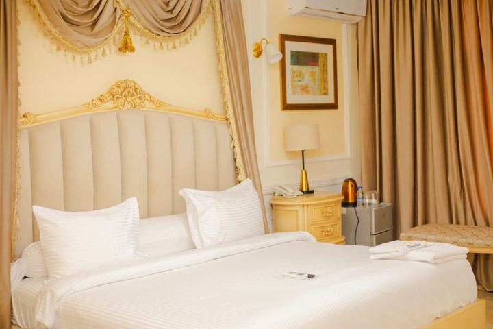 Suite Royale avec lit à baldaquin et rideaux drapés